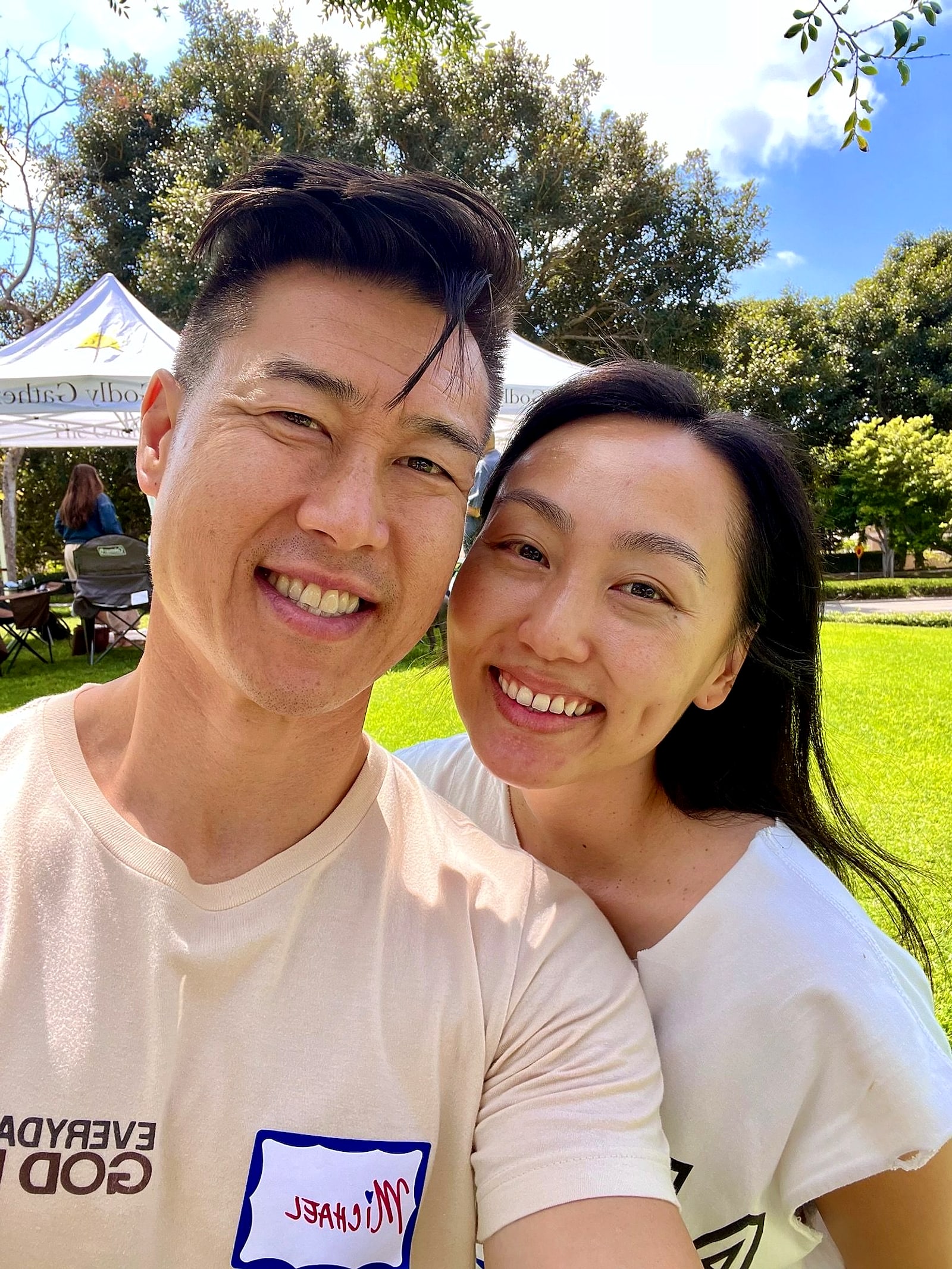 Michael and Alexis Thai smiling together in a park