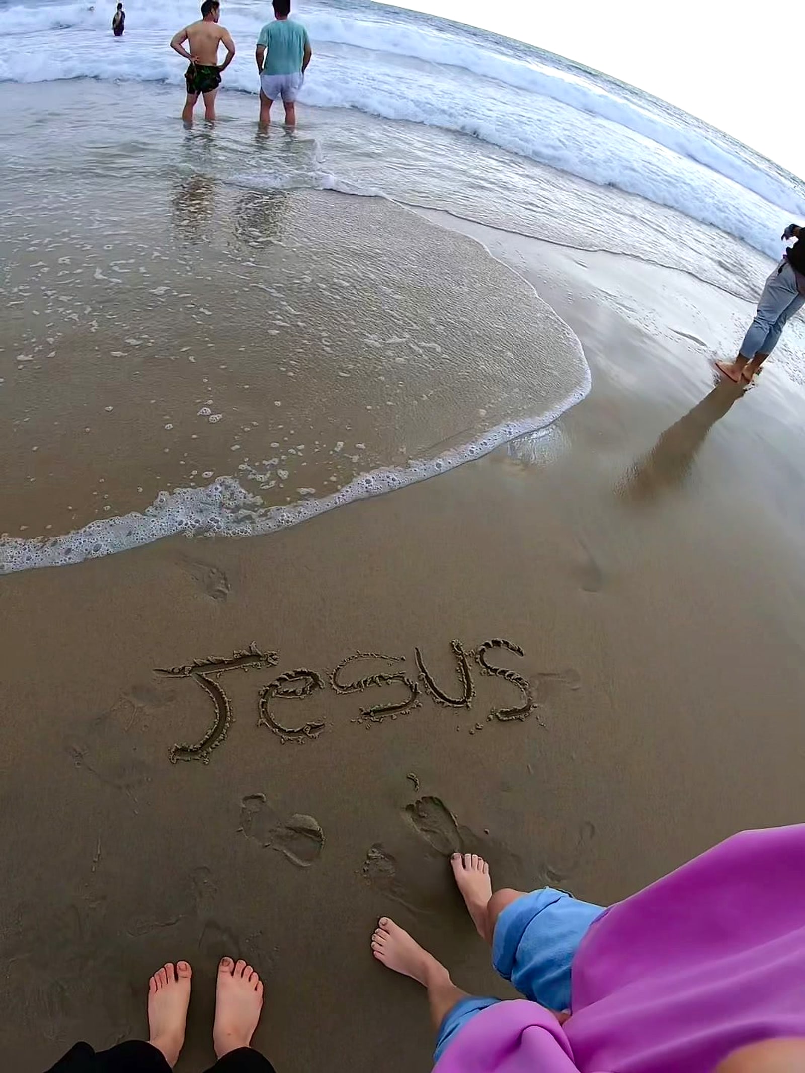 The name Jesus written in the wet sand