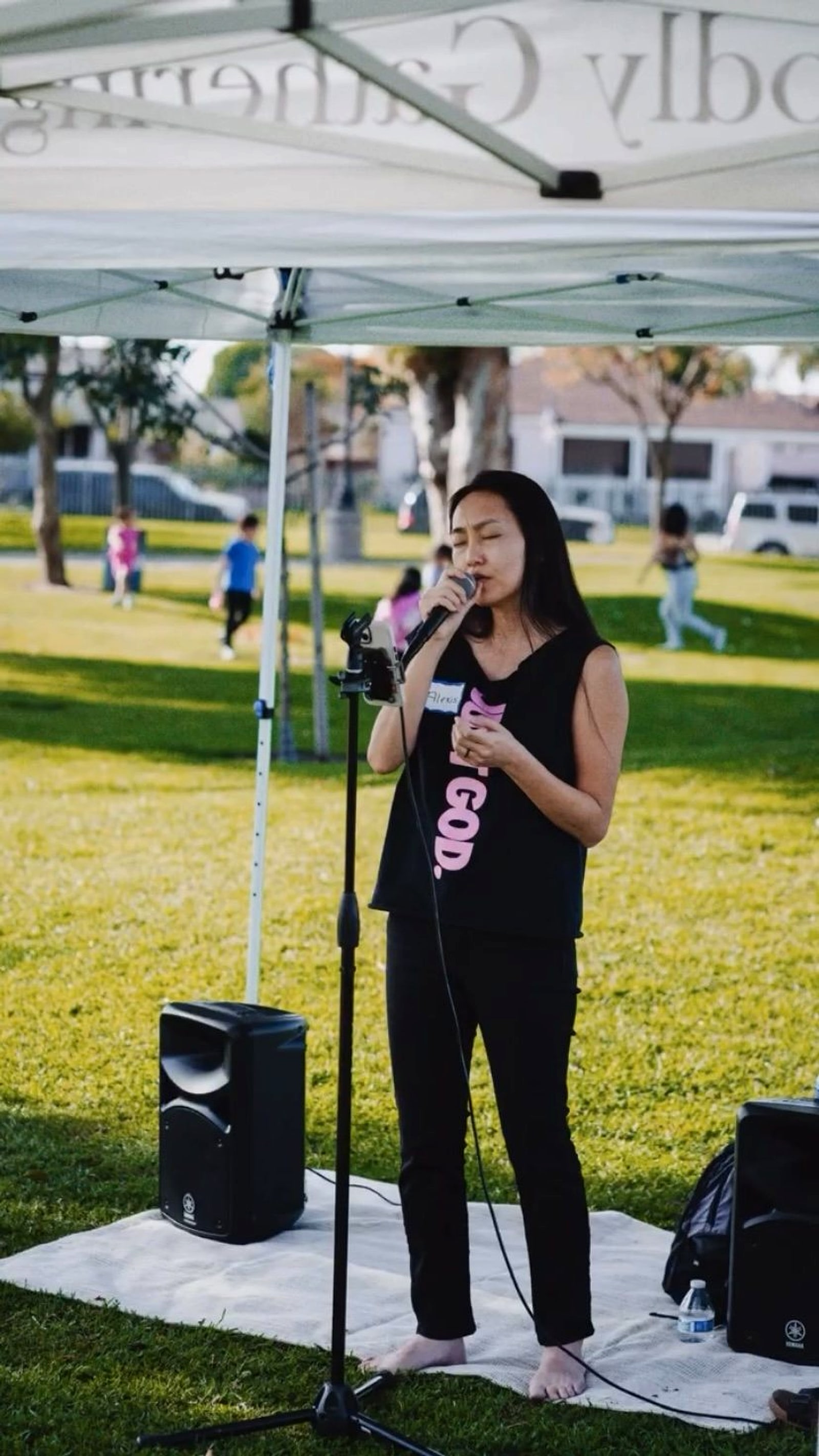A woman sharing with a microphone under the canopy